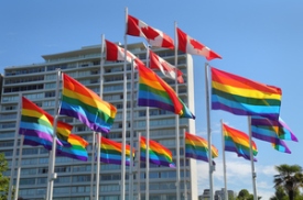 Rainbow colored Gay Pride Flags and Canadian Flags flutter in the wind in Vancouver. British Columbia, Canada.
